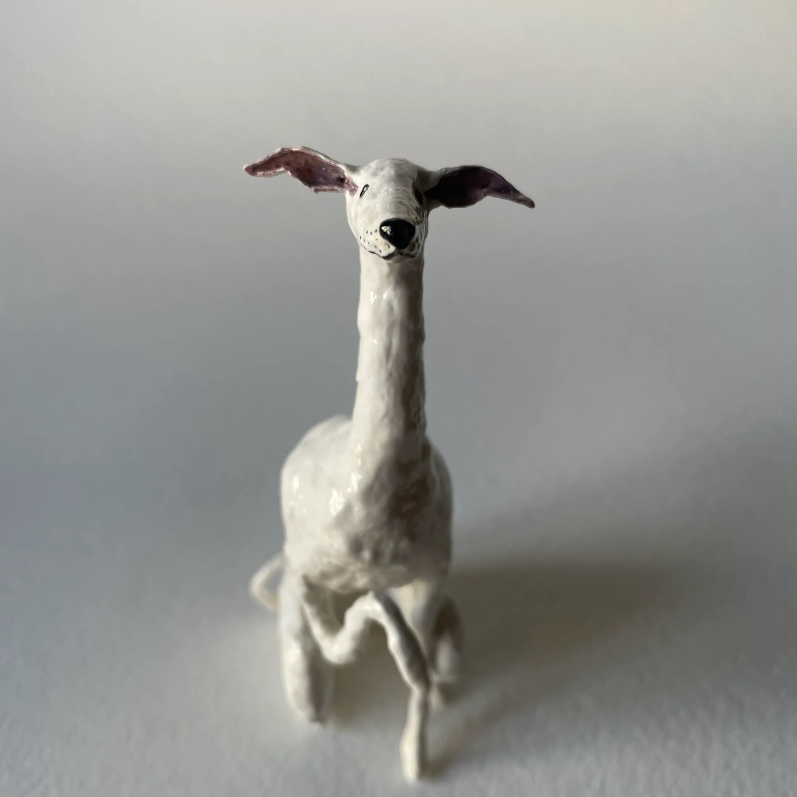 Miniature white sighthound figurine